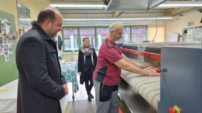 Herr Kleinau (re.) zeigt Thomas Staudt MdL und D�rthe Wallbaum seinen Arbeitsplatz an der Hei�mangel